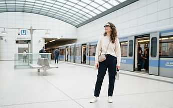 Frau mit AR-Brille auf einem hellen U-Bahnsteig in Deutschland
